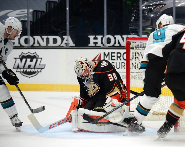 Feb 5, 2021; Anaheim, California, USA; Anaheim Ducks goaltender John Gibson (36) blocks a shot against San Jose Sharks left wing Evander Kane (9) as center Logan Couture (39) moves in for the rebound during the overtime period at Honda Center. Mandatory Credit: Gary A. Vasquez-USA TODAY Sports