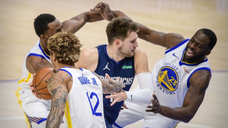 Feb 6, 2021; Dallas, Texas, USA; Dallas Mavericks guard Luka Doncic (77) drives to the basket past Golden State Warriors forward Andrew Wiggins (22) and guard Kelly Oubre Jr. (12) and forward Draymond Green (23) during the first quarter at the American Airlines Center. Mandatory Credit: Jerome Miron-USA TODAY Sports