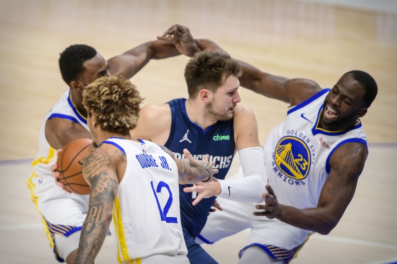 Feb 6, 2021; Dallas, Texas, USA; Dallas Mavericks guard Luka Doncic (77) drives to the basket past Golden State Warriors forward Andrew Wiggins (22) and guard Kelly Oubre Jr. (12) and forward Draymond Green (23) during the first quarter at the American Airlines Center. Mandatory Credit: Jerome Miron-USA TODAY Sports