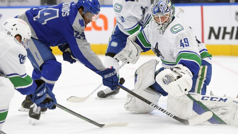 Feb 6, 2021; Toronto, Ontario, CAN; Vancouver Canucks goalie Braden Holtby (49) makes a save against Toronto Maple Leafs forward Wayne Simmonds (24) in the first period at Scotiabank Arena. Mandatory Credit: Dan Hamilton-USA TODAY Sports