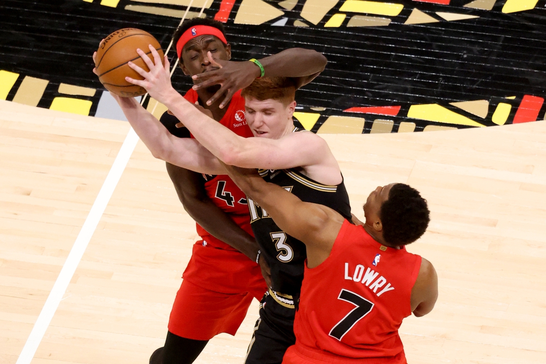 Feb 6, 2021; Atlanta, Georgia, USA; Atlanta Hawks guard Kevin Huerter (3) controls the ball while defended by Toronto Raptors forward Pascal Siakam (L) and guard Kyle Lowry (7) in the second half at State Farm Arena. Mandatory Credit: Jason Getz-USA TODAY Sports