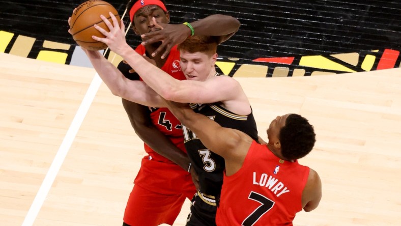 Feb 6, 2021; Atlanta, Georgia, USA; Atlanta Hawks guard Kevin Huerter (3) controls the ball while defended by Toronto Raptors forward Pascal Siakam (L) and guard Kyle Lowry (7) in the second half at State Farm Arena. Mandatory Credit: Jason Getz-USA TODAY Sports