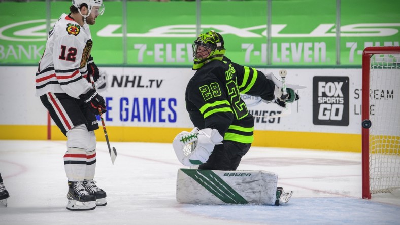 Feb 7, 2021; Dallas, Texas, USA; Chicago Blackhawks left wing Alex DeBrincat (12) watches a shot get past Dallas Stars goaltender Jake Oettinger (29) during the first period at the American Airlines Center. Upon review the call on the ice was no goal. Mandatory Credit: Jerome Miron-USA TODAY Sports