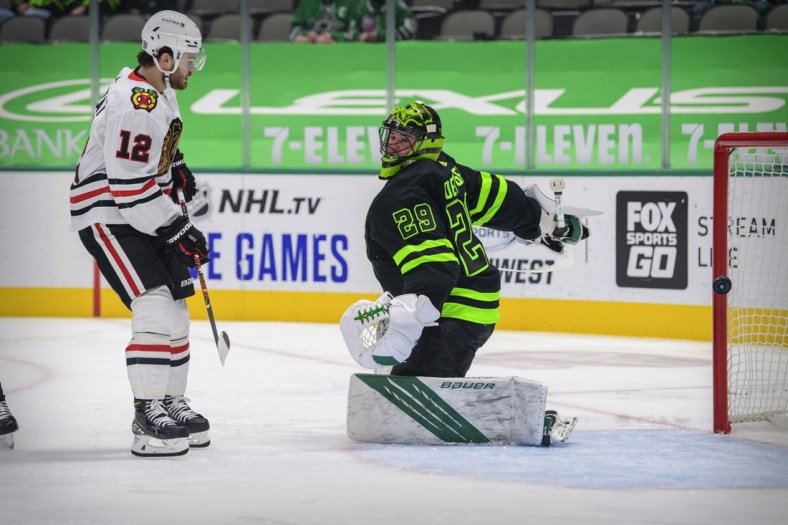 Feb 7, 2021; Dallas, Texas, USA; Chicago Blackhawks left wing Alex DeBrincat (12) watches a shot get past Dallas Stars goaltender Jake Oettinger (29) during the first period at the American Airlines Center. Upon review the call on the ice was no goal. Mandatory Credit: Jerome Miron-USA TODAY Sports