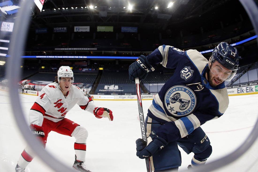 Feb 7, 2021; Columbus, Ohio, USA; Columbus Blue Jackets center Liam Foudy (19) carries the puck as Carolina Hurricanes defenseman Haydn Fleury (4) defends during the third period at Nationwide Arena. Mandatory Credit: Russell LaBounty-USA TODAY Sports