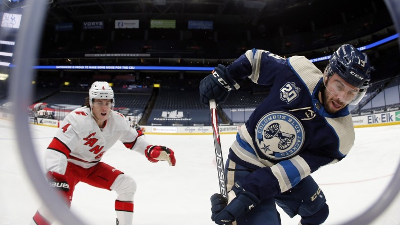 Feb 7, 2021; Columbus, Ohio, USA; Columbus Blue Jackets center Liam Foudy (19) carries the puck as Carolina Hurricanes defenseman Haydn Fleury (4) defends during the third period at Nationwide Arena. Mandatory Credit: Russell LaBounty-USA TODAY Sports