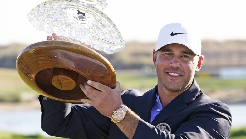 Feb 7, 2021; Scottsdale, Arizona, USA; Brooks Koepka poses with the trophy after winning the Waste Management Phoenix Open at TPC Scottsdale. Mandatory Credit: Rob Schumacher-USA TODAY Sports