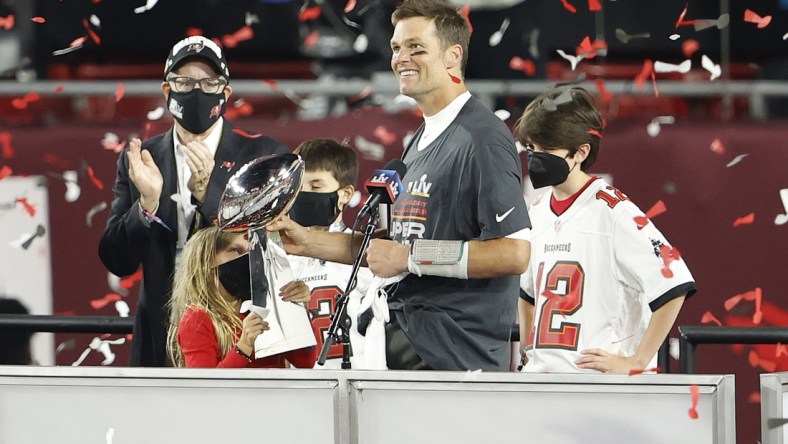 Feb 7, 2020; Tampa, FL, USA; Tampa Bay Buccaneers quarterback Tom Brady (12) hands the Lombardi Trophy to his children after Super Bowl LV at Raymond James Stadium.  Mandatory Credit: Kim Klement-USA TODAY Sports