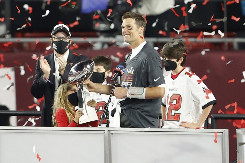 Feb 7, 2020; Tampa, FL, USA; Tampa Bay Buccaneers quarterback Tom Brady (12) hands the Lombardi Trophy to his children after Super Bowl LV at Raymond James Stadium.  Mandatory Credit: Kim Klement-USA TODAY Sports
