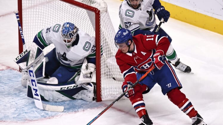Feb 02, 2021; Montreal, Quebec, CAN; Montreal Canadiens right wing Brendan Gallagher (11) shoots the puck against Vancouver Canucks goaltender Thatcher Demko (35) as defenseman Jalen Chatfield (63) defends  defends during the second period at Bell Centre. Mandatory Credit: Jean-Yves Ahern-USA TODAY Sports