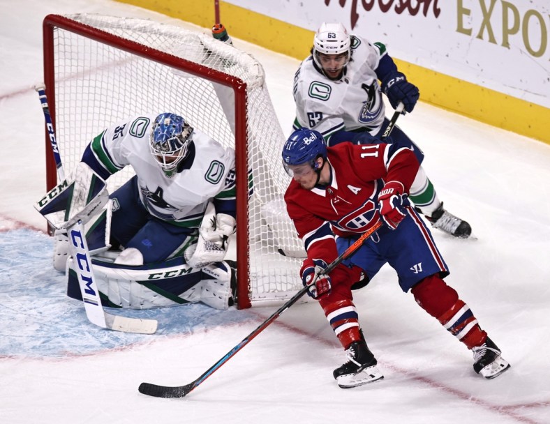 Feb 02, 2021; Montreal, Quebec, CAN; Montreal Canadiens right wing Brendan Gallagher (11) shoots the puck against Vancouver Canucks goaltender Thatcher Demko (35) as defenseman Jalen Chatfield (63) defends  defends during the second period at Bell Centre. Mandatory Credit: Jean-Yves Ahern-USA TODAY Sports