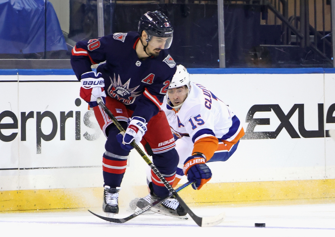 Feb 8, 2021; New York, NY, USA; Chris Kreider #20 of the New York Rangers moves the puck away from Cal Clutterbuck #15 of the New York Islanders during the first period at Madison Square Garden on February 08, 2021 in New York City. Mandatory Credit: Bruce Bennett/Pool Photo-USA TODAY Sports