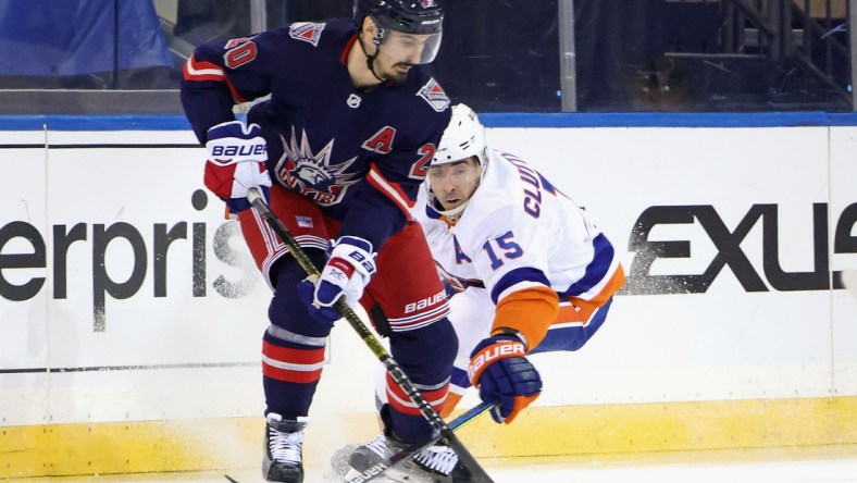 Feb 8, 2021; New York, NY, USA; Chris Kreider #20 of the New York Rangers moves the puck away from Cal Clutterbuck #15 of the New York Islanders during the first period at Madison Square Garden on February 08, 2021 in New York City. Mandatory Credit: Bruce Bennett/Pool Photo-USA TODAY Sports