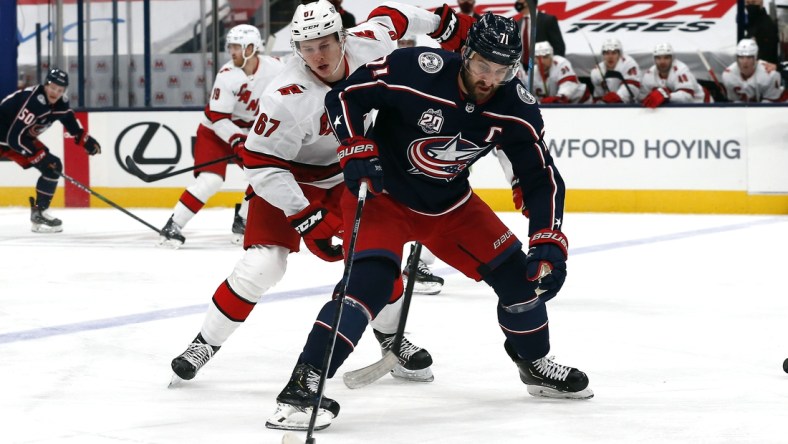 Feb 8, 2021; Columbus, Ohio, USA; Columbus Blue Jackets left wing Nick Foligno (71) settles down rolling puck as Carolina Hurricanes center Morgan Geekie (67) trails the playduring the first period at Nationwide Arena. Mandatory Credit: Russell LaBounty-USA TODAY Sports