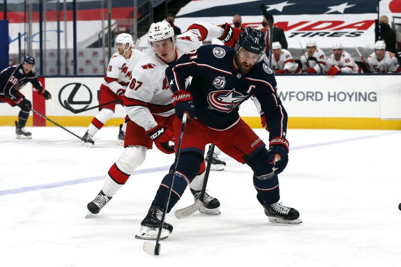 Feb 8, 2021; Columbus, Ohio, USA; Columbus Blue Jackets left wing Nick Foligno (71) settles down rolling puck as Carolina Hurricanes center Morgan Geekie (67) trails the playduring the first period at Nationwide Arena. Mandatory Credit: Russell LaBounty-USA TODAY Sports