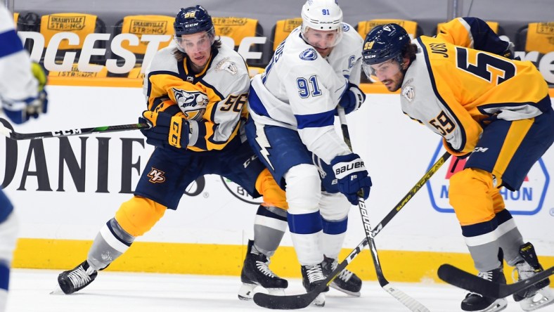 Feb 8, 2021; Nashville, Tennessee, USA; Tampa Bay Lightning center Steven Stamkos (91) works to get the puck against Nashville Predators left wing Erik Haula (56) and Nashville Predators defenseman Roman Josi (59) during the third period at Bridgestone Arena. Mandatory Credit: Christopher Hanewinckel-USA TODAY Sports