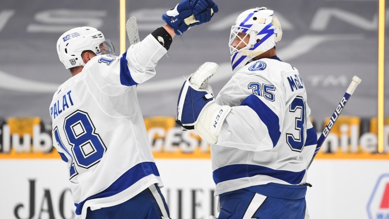 Feb 8, 2021; Nashville, Tennessee, USA; Tampa Bay Lightning goaltender Curtis McElhinney (35) is congratulated by Tampa Bay Lightning left wing Ondrej Palat (18) after a win against the Nashville Predators at Bridgestone Arena. Mandatory Credit: Christopher Hanewinckel-USA TODAY Sports