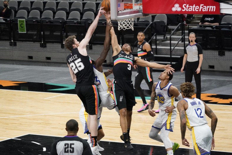 Feb 9, 2021; San Antonio, Texas, USA; San Antonio Spurs center Jakob Poeltl (25) and forward Keldon Johnson (3) go after a rebound against Golden State Warriors forward Draymond Green (23) in the first quarter at AT&T Center. Mandatory Credit: Scott Wachter-USA TODAY Sports
