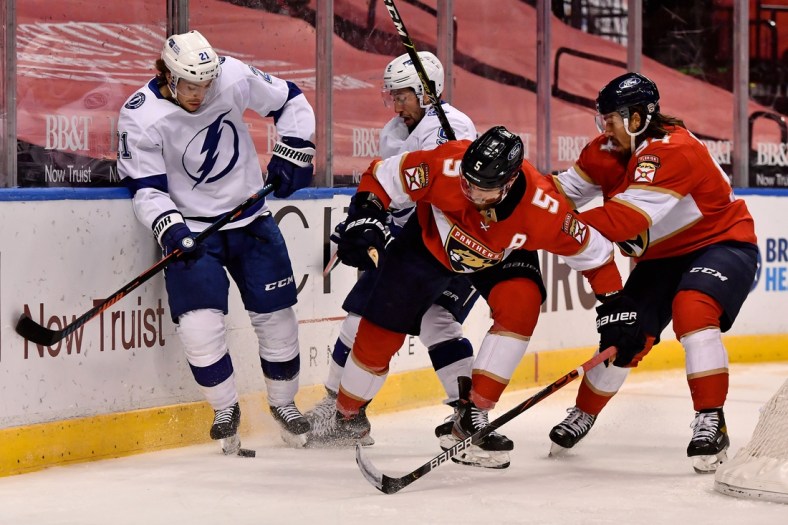 Feb 11, 2021; Sunrise, Florida, USA; Tampa Bay Lightning center Brayden Point (21) and Florida Panthers defenseman Aaron Ekblad (5) battle for the puck in front of Tampa Bay Lightning center Tyler Johnson (9) and Florida Panthers left wing Ryan Lomberg (94) during the first period at BB&T Center. Mandatory Credit: Jasen Vinlove-USA TODAY Sports