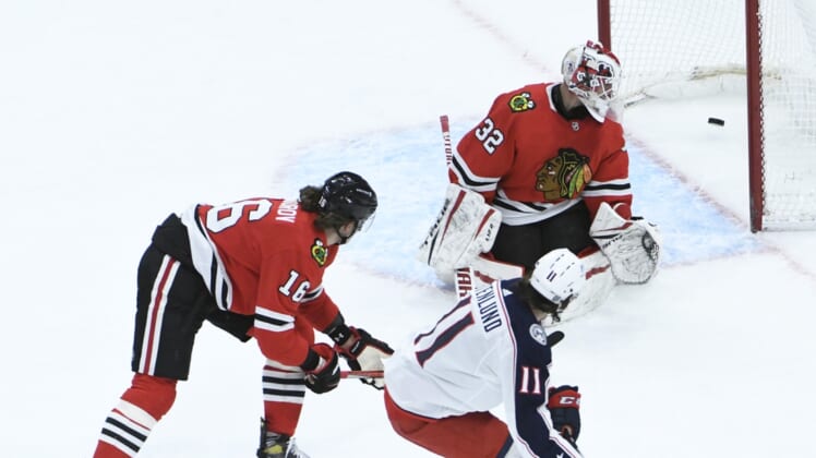 Feb 11, 2021; Chicago, Illinois, USA; Columbus Blue Jackets center Kevin Stenlund (11) scores a goal on Chicago Blackhawks goaltender Kevin Lankinen (32) during the third period at United Center. Mandatory Credit: David Banks-USA TODAY Sports