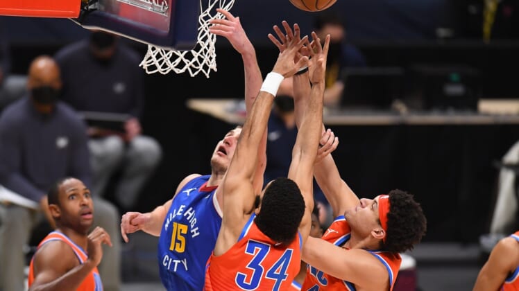 Feb 12, 2021; Denver, Colorado, USA; Denver Nuggets center Nikola Jokic (15) and Oklahoma City Thunder guard Kenrich Williams (34) and forward Justin Jackson (44) reach for a rebound in the second quarter at Ball Arena. Mandatory Credit: Ron Chenoy-USA TODAY Sports