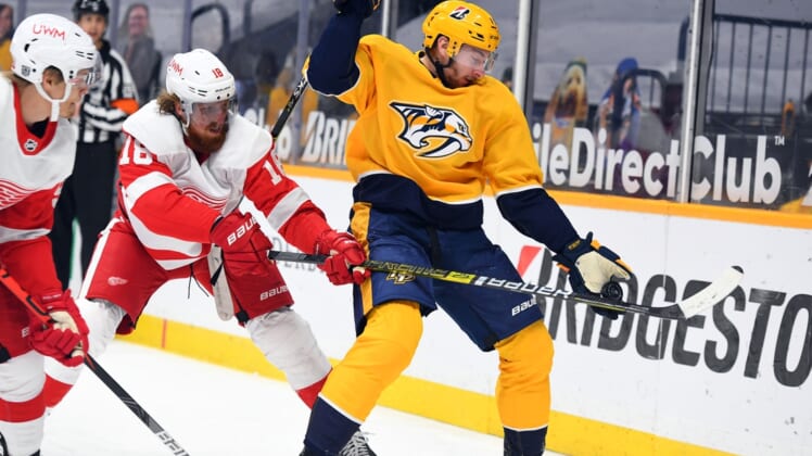 Feb 13, 2021; Nashville, Tennessee, USA; Nashville Predators center Yakov Trenin (13) plays the puck out of the air against Detroit Red Wings defenseman Marc Staal (18) during the first period at Bridgestone Arena. Mandatory Credit: Christopher Hanewinckel-USA TODAY Sports