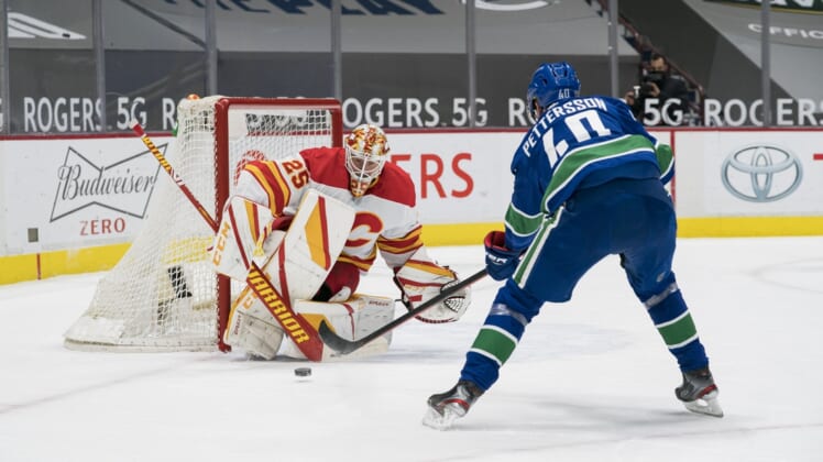 Feb 13, 2021; Vancouver, British Columbia, CAN; Calgary Flames goalie Jacob Markstrom (25) makes a save against Vancouver Canucks forward Elias Pettersson (40) in the first period at Rogers Arena. Mandatory Credit: Bob Frid-USA TODAY Sports
