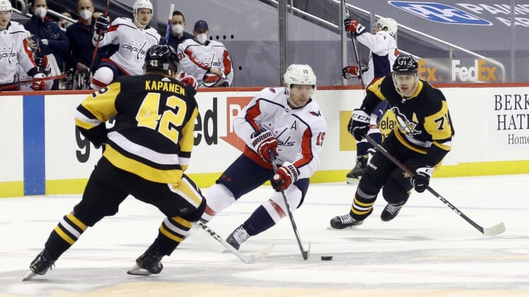 Feb 14, 2021; Pittsburgh, Pennsylvania, USA;  Washington Capitals center Nicklas Backstrom (19) carries the puck between Pittsburgh Penguins right wing Kasperi Kapanen (42) and center Evgeni Malkin (71) during the first period at PPG Paints Arena. Mandatory Credit: Charles LeClaire-USA TODAY Sports