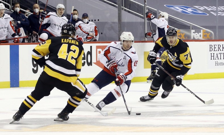 Feb 14, 2021; Pittsburgh, Pennsylvania, USA;  Washington Capitals center Nicklas Backstrom (19) carries the puck between Pittsburgh Penguins right wing Kasperi Kapanen (42) and center Evgeni Malkin (71) during the first period at PPG Paints Arena. Mandatory Credit: Charles LeClaire-USA TODAY Sports