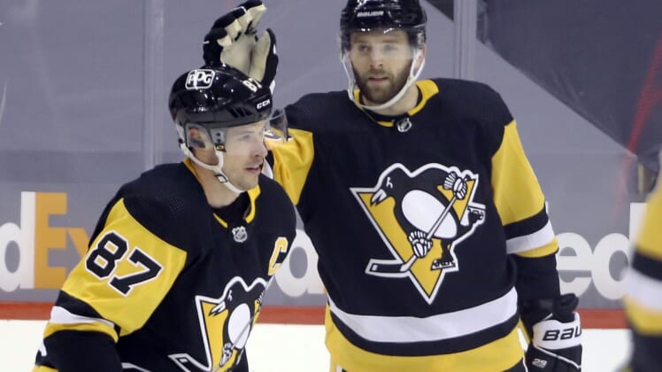 Feb 14, 2021; Pittsburgh, Pennsylvania, USA;  Pittsburgh Penguins right wing Bryan Rust (17) congratulates center Sidney Crosby (87) on his goal against the Washington Capitals during the third period at PPG Paints Arena. The Penguins won 6-3. Mandatory Credit: Charles LeClaire-USA TODAY Sports