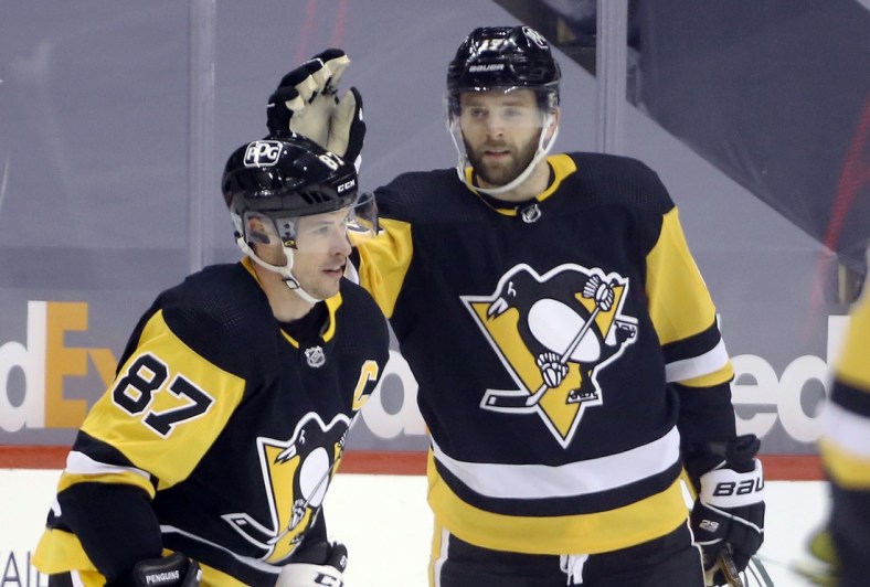 Feb 14, 2021; Pittsburgh, Pennsylvania, USA;  Pittsburgh Penguins right wing Bryan Rust (17) congratulates center Sidney Crosby (87) on his goal against the Washington Capitals during the third period at PPG Paints Arena. The Penguins won 6-3. Mandatory Credit: Charles LeClaire-USA TODAY Sports