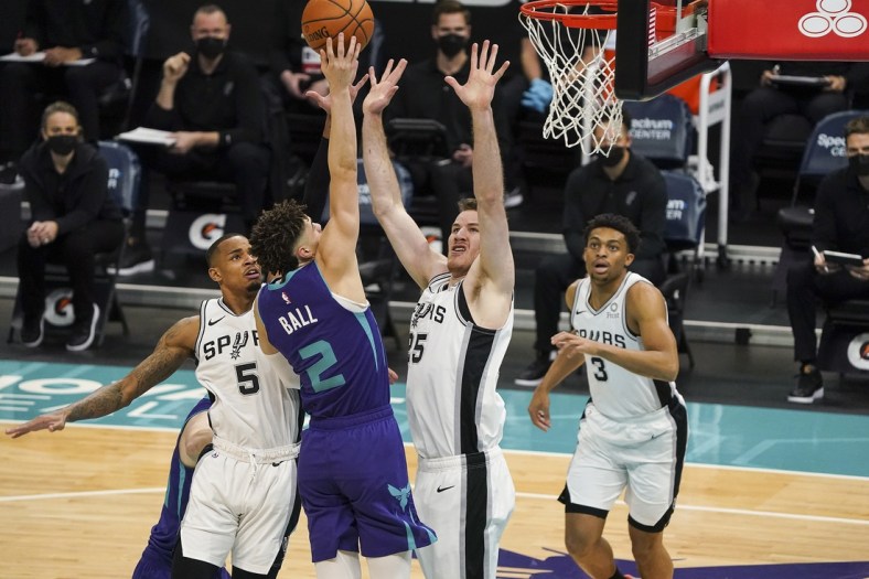 Feb 14, 2021; Charlotte, North Carolina, USA;Charlotte Hornets guard LaMelo Ball (2) goes up for a shot defended by San Antonio Spurs center Jakob Poeltl (25) during the first quarter at Spectrum Center. Mandatory Credit: Jim Dedmon-USA TODAY Sports