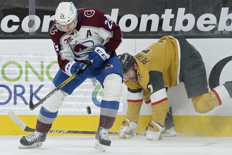 Feb 14, 2021; Las Vegas, Nevada, USA; Colorado Avalanche center Nathan MacKinnon (29) vies for the puck with Vegas Golden Knights defenseman Alex Pietrangelo (7) during the third period at T-Mobile Arena. Mandatory Credit:  John Locher/Pool Photo-USA TODAY Sports