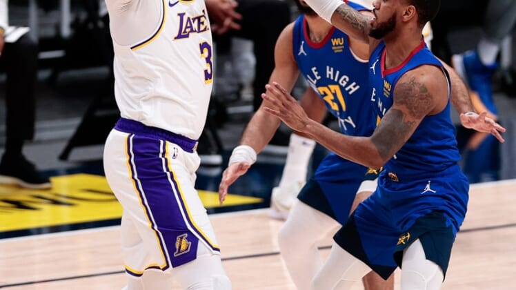Feb 14, 2021; Denver, Colorado, USA; Los Angeles Lakers forward Anthony Davis (3) controls the ball under pressure from Denver Nuggets guard Monte Morris (11) and guard Jamal Murray (27) in the first quarter at Ball Arena. Mandatory Credit: Isaiah J. Downing-USA TODAY Sports