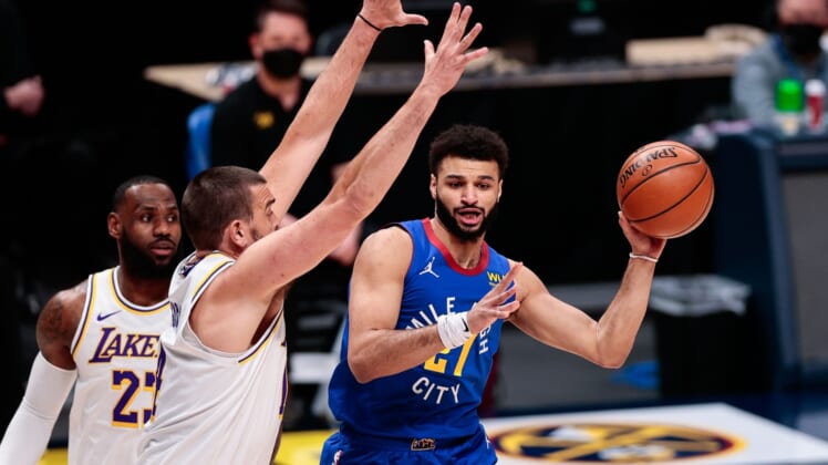 Feb 14, 2021; Denver, Colorado, USA; Denver Nuggets guard Jamal Murray (27) passes the ball away from Los Angeles Lakers center Marc Gasol (14) in the first quarter at Ball Arena. Mandatory Credit: Isaiah J. Downing-USA TODAY Sports