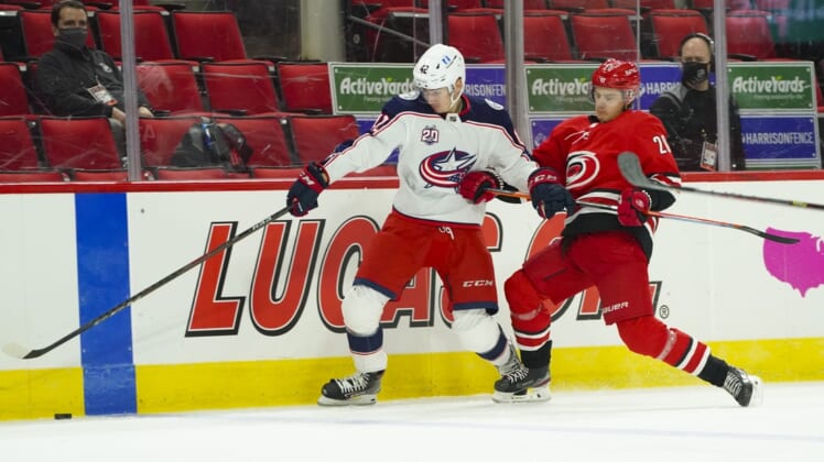 Feb 15, 2021; Raleigh, North Carolina, USA; Columbus Blue Jackets center Alexandre Texier (42) and Carolina Hurricanes right wing Sebastian Aho (20) chase after the puck during the first period at PNC Arena. Mandatory Credit: James Guillory-USA TODAY Sports