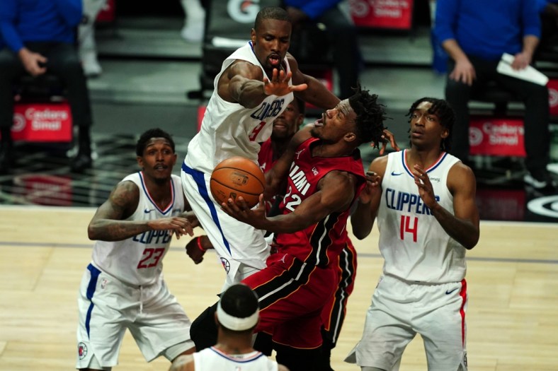 Feb 15, 2021; Los Angeles, California, USA;Miami Heat forward Jimmy Butler (22) is defended by LA Clippers guard Lou Williams (23) and center Serge Ibaka (9) and guard Terance Mann (14) in the second  half at Staples Center. Mandatory Credit: Kirby Lee-USA TODAY Sports