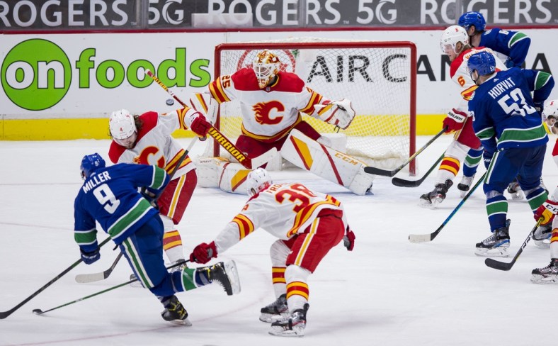Feb 15, 2021; Vancouver, British Columbia, CAN; Calgary Flames goalie Jacob Markstrom (25) makes a save on shot form Vancouver Canucks forward J.T. Miller (9) in the third period period at Rogers Arena. Flames won 4-3 in Overtime. Mandatory Credit: Bob Frid-USA TODAY Sports
