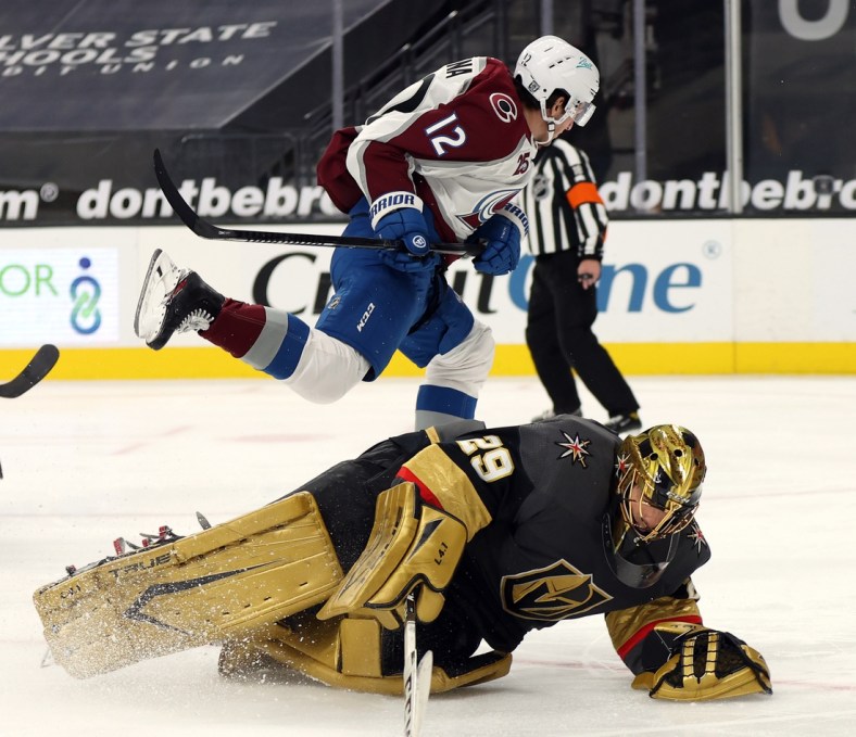 Feb 16, 2021; Las Vegas, Nevada, USA; Colorado Avalanche center Jayson Megna (12) skates over Vegas Golden Knights goalie Marc-Andre Fleury (29) during the third period at T-Mobile Arena. Mandatory Credit:  Isaac Brekken/Pool Photos-USA TODAY Sports