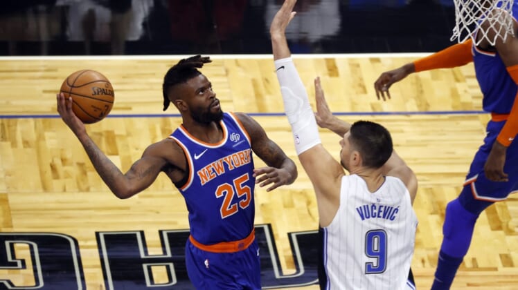 Feb 17, 2021; Orlando, Florida, USA; New York Knicks forward Reggie Bullock (25) moves to the basket as Orlando Magic guard Chasson Randle (9) defends during the first quarter at Amway Center. Mandatory Credit: Kim Klement-USA TODAY Sports