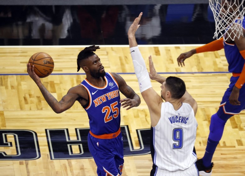 Feb 17, 2021; Orlando, Florida, USA; New York Knicks forward Reggie Bullock (25) moves to the basket as Orlando Magic guard Chasson Randle (9) defends during the first quarter at Amway Center. Mandatory Credit: Kim Klement-USA TODAY Sports