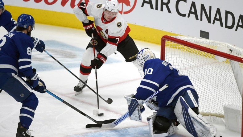 Feb 18, 2021; Toronto, Ontario, CAN;  Ottawa Senators forward Brady Tkachuk (7) shoots the puck as Toronto Maple Leafs goalie Michael Hutchinson (30) defends in the first period at Scotiabank Arena. Mandatory Credit: Dan Hamilton-USA TODAY Sports