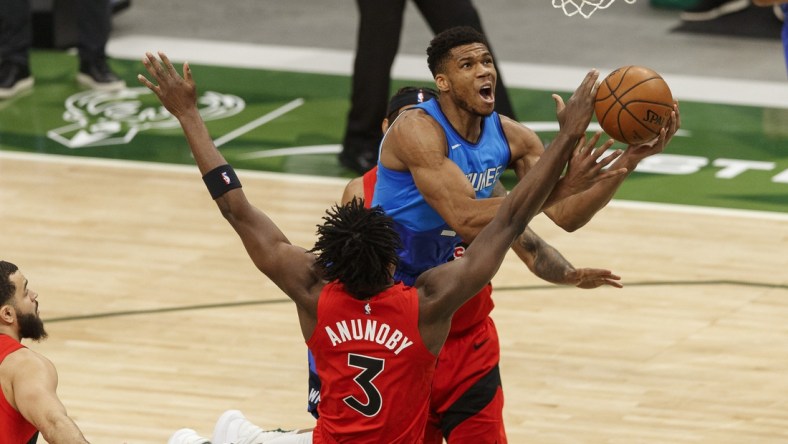 Feb 18, 2021; Milwaukee, Wisconsin, USA;  Milwaukee Bucks forward Giannis Antetokounmpo (34) shoots against Toronto Raptors forward OG Anunoby (3) during the first quarter at Fiserv Forum. Mandatory Credit: Jeff Hanisch-USA TODAY Sports