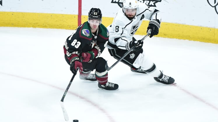 Feb 18, 2021; Glendale, Arizona, USA; Arizona Coyotes right wing Conor Garland (83) steals the puck from Los Angeles Kings defenseman Drew Doughty (8) during the first period at Gila River Arena. Mandatory Credit: Matt Kartozian-USA TODAY Sports
