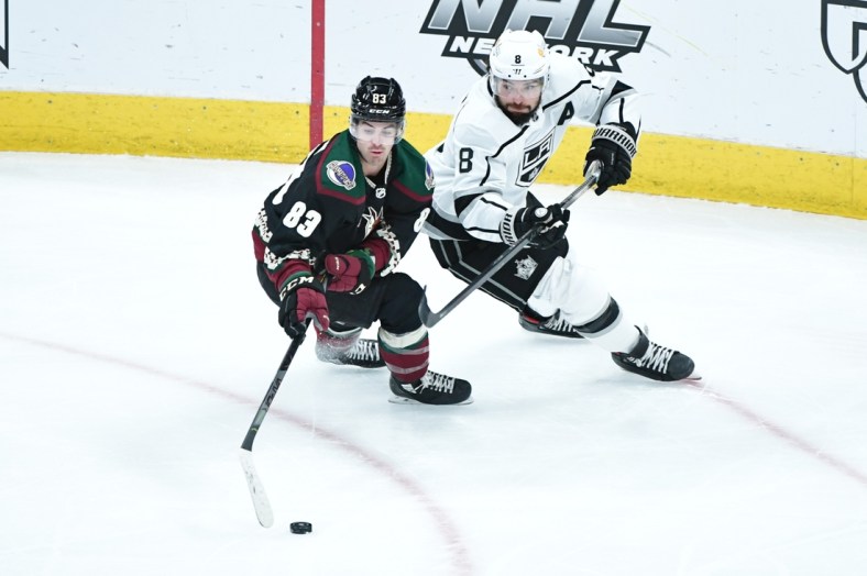 Feb 18, 2021; Glendale, Arizona, USA; Arizona Coyotes right wing Conor Garland (83) steals the puck from Los Angeles Kings defenseman Drew Doughty (8) during the first period at Gila River Arena. Mandatory Credit: Matt Kartozian-USA TODAY Sports