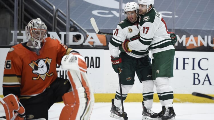 Feb 18, 2021; Anaheim, California, USA; Minnesota Wild left wing Marcus Foligno (17) celebrates is goal with left wing Zach Parise (11) as Anaheim Ducks goalie John Gibson (36) looks on during the third period at Honda Center. Mandatory Credit: Kelvin Kuo-USA TODAY Sports
