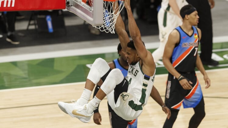 Feb 19, 2021; Milwaukee, Wisconsin, USA;  Milwaukee Bucks forward Giannis Antetokounmpo (34) hangs from the rim following a dunk during the third quarter against the Oklahoma City Thunder at Fiserv Forum. Mandatory Credit: Jeff Hanisch-USA TODAY Sports