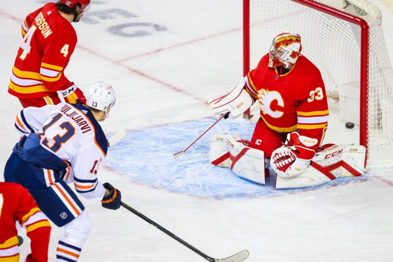Feb 19, 2021; Calgary, Alberta, CAN; Calgary Flames goaltender David Rittich (33) reacts as Edmonton Oilers right wing Jesse Puljujarvi (13) scores a goal during the first period at Scotiabank Saddledome. Mandatory Credit: Sergei Belski-USA TODAY Sports