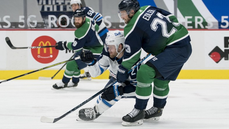 Feb 19, 2021; Vancouver, British Columbia, CAN; Vancouver Canucks defenseman Alexander Edler (23) checks Winnipeg Jets forward Nikolaj Ehlers (27) in the second period at Rogers Arena. Mandatory Credit: Bob Frid-USA TODAY Sports