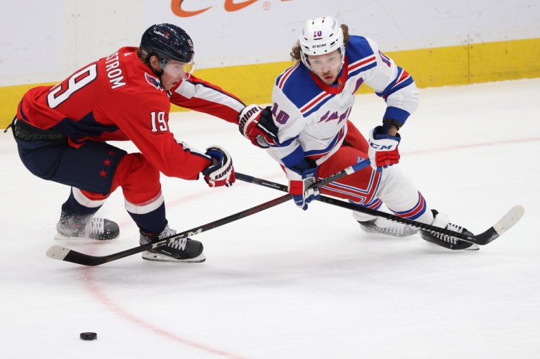 Feb 20, 2021; Washington, District of Columbia, USA; Washington Capitals center Nicklas Backstrom (19) and New York Rangers left wing Artemi Panarin (10) battle for the puck in the first period at Capital One Arena. Mandatory Credit: Geoff Burke-USA TODAY Sports